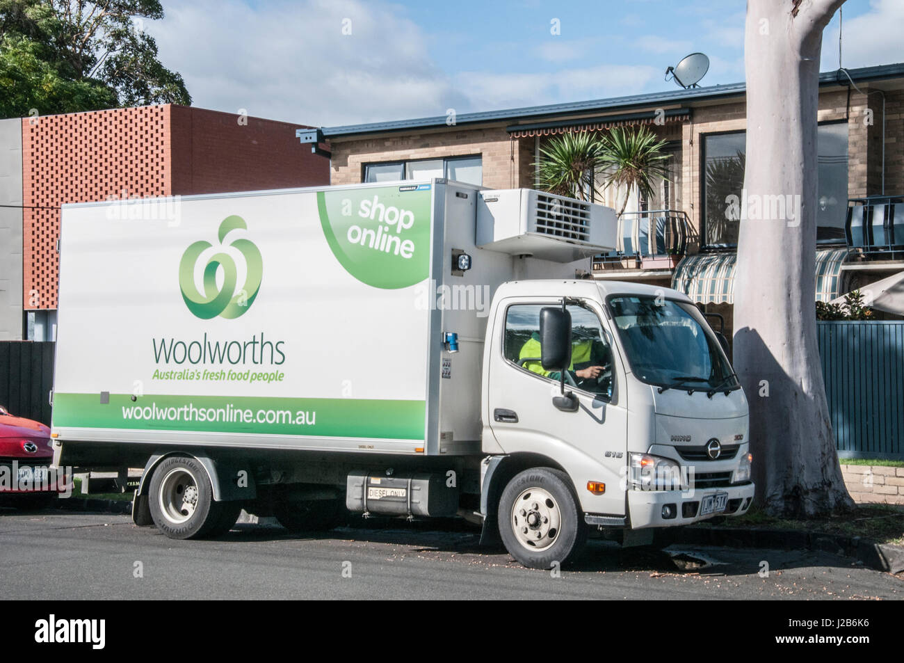 Woolworths truck delivering groceries purchased online to a suburban