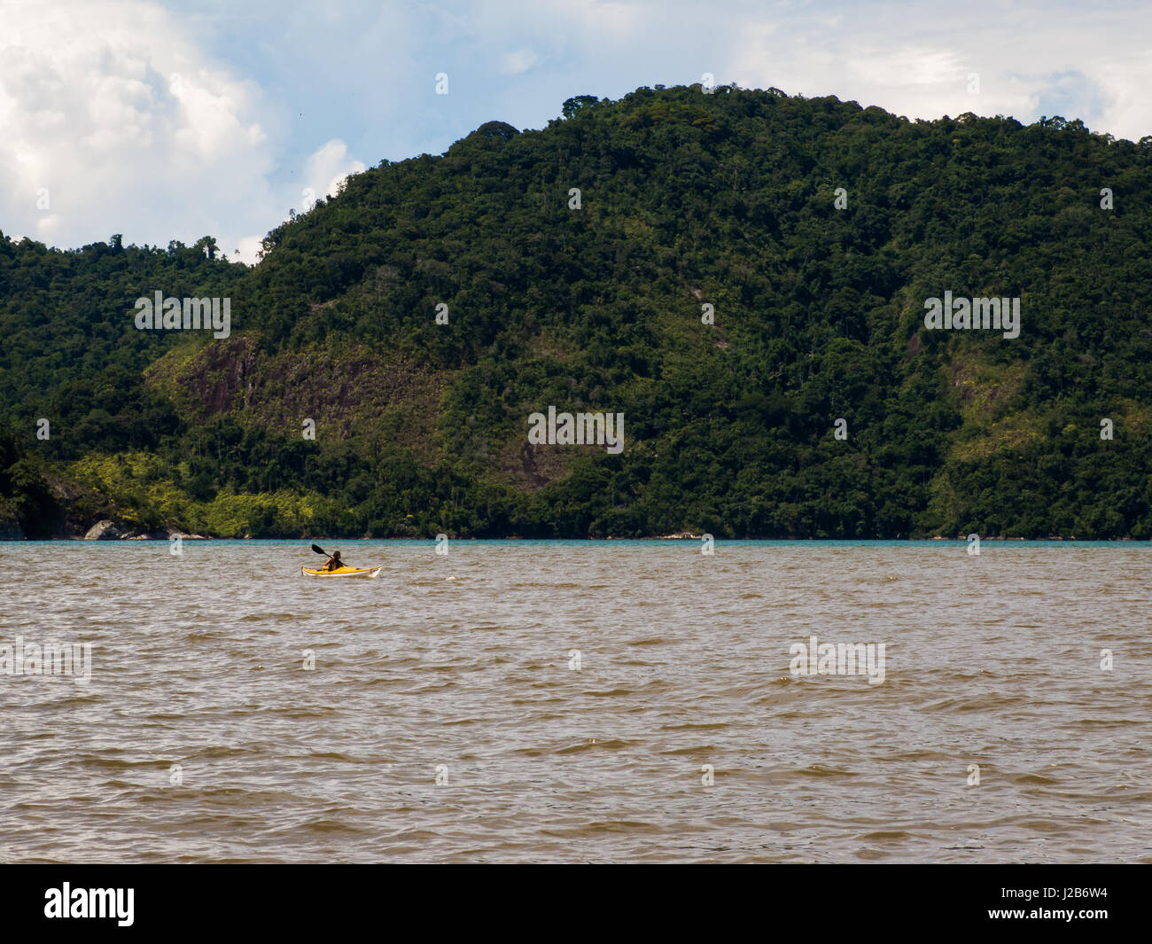 Man paddling kayak alone in Paratimirim bay, in Paraty, near Rio de Janeiro, Brazil. Stock Photo