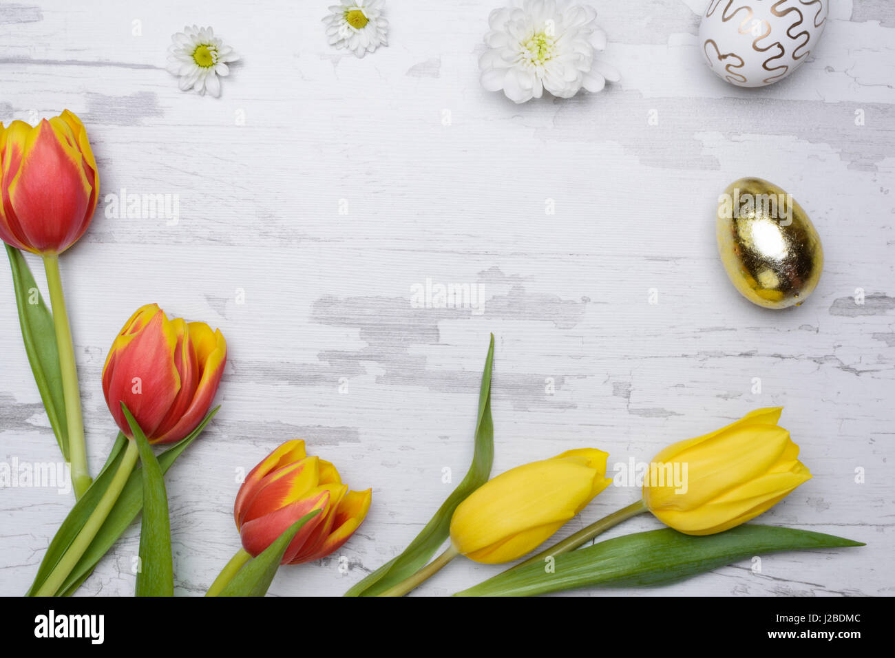 Easter eggs and tulips over wooden background Stock Photo - Alamy