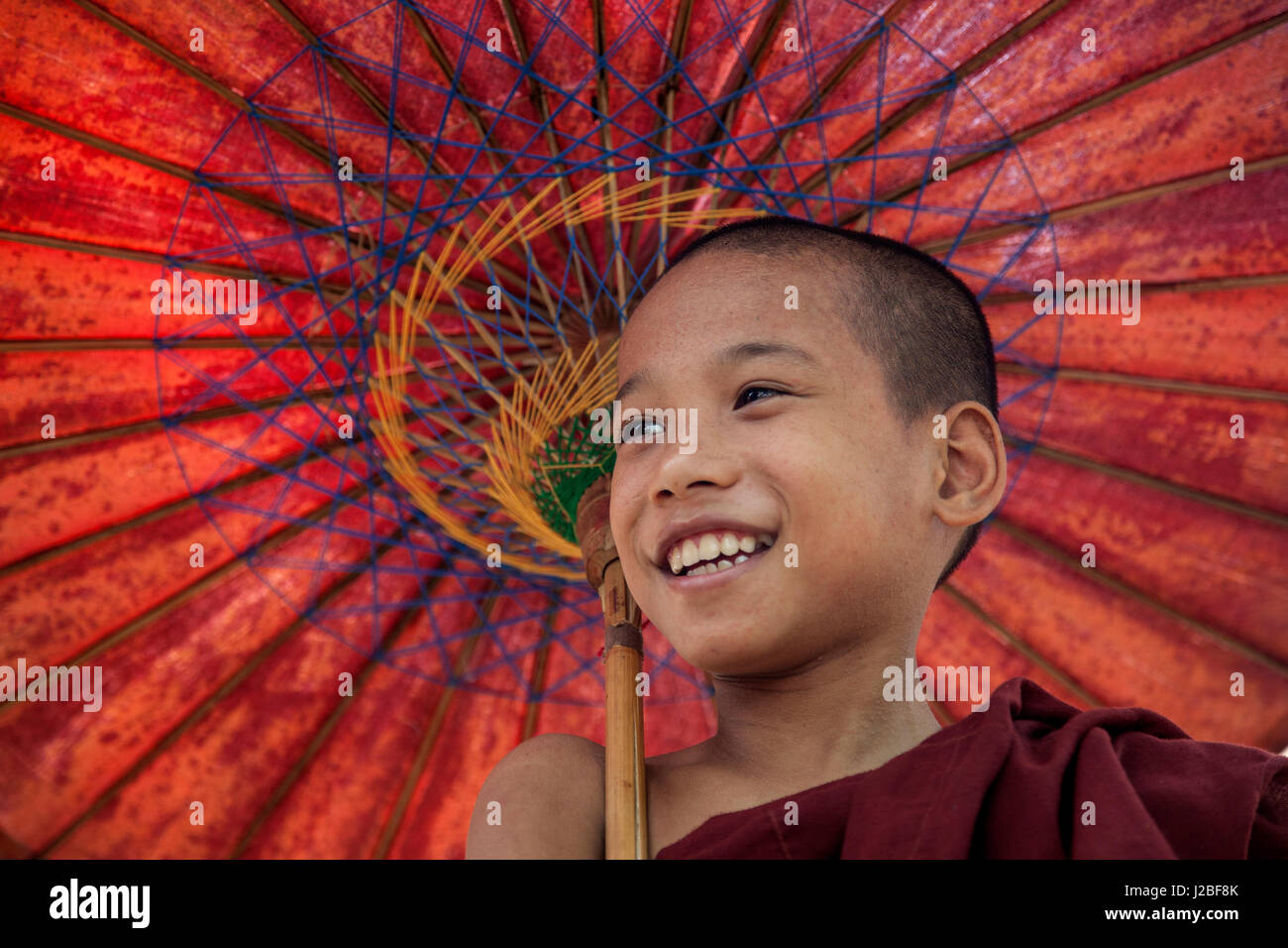 Myanmar, Mandalay. Portrait of novice monk with umbrella. Credit as: Jim Zuckerman / Jaynes Gallery / DanitaDelimont.com Stock Photo