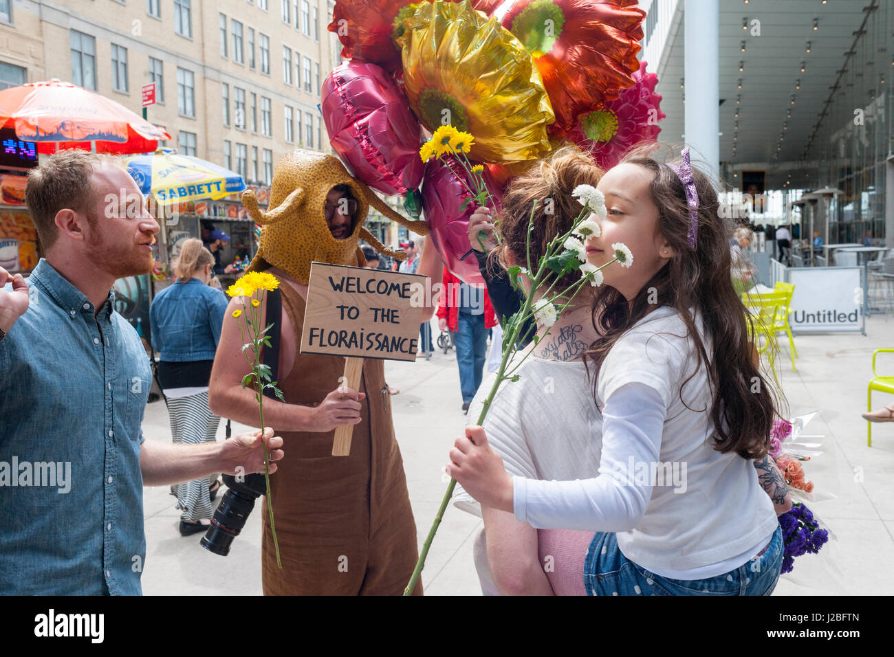 The Brazilian artist, André Feliciano known as the 'art gardener' prior to his procession on the High Line Park in New York on Sunday, April 23, 2017 distributes flowers to passer-by in his performance art piece, the Floraissance parade. The Floraissance is an art movement created by Feliciano based on the idea that contemporary cannot describe art anymore and we art moving into the next phase, growing like flowers, into the Floraissance. (© Richard B. Levine) Stock Photo