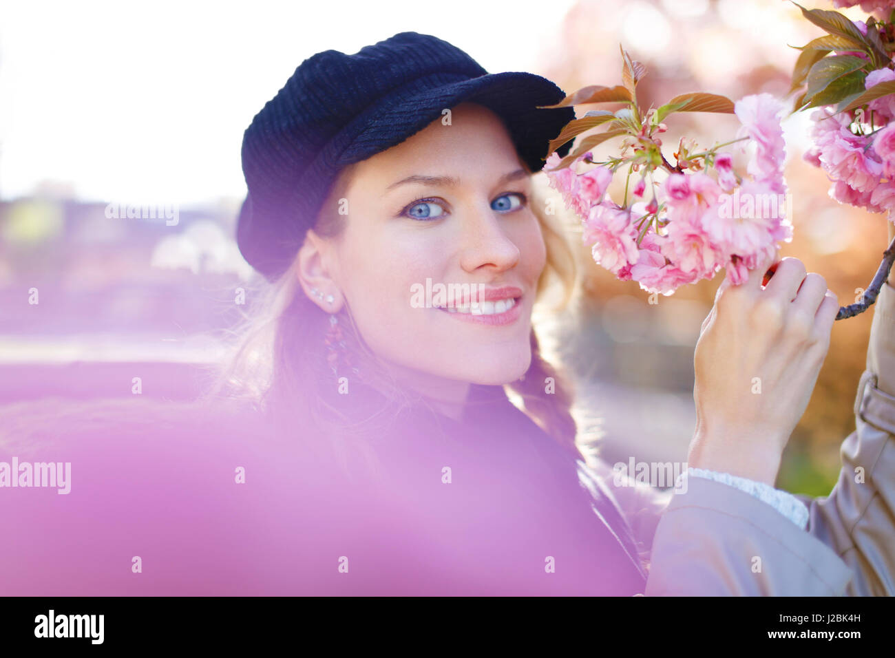 Young woman holding cherry blossom in park Stock Photo