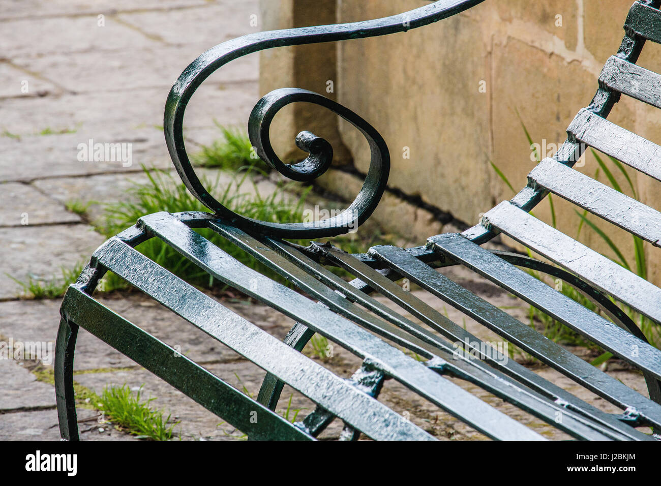 Close up detail of a green painted metal bench in a park. Curved arm rest. Ta Qali National Park, Malta Stock Photo
