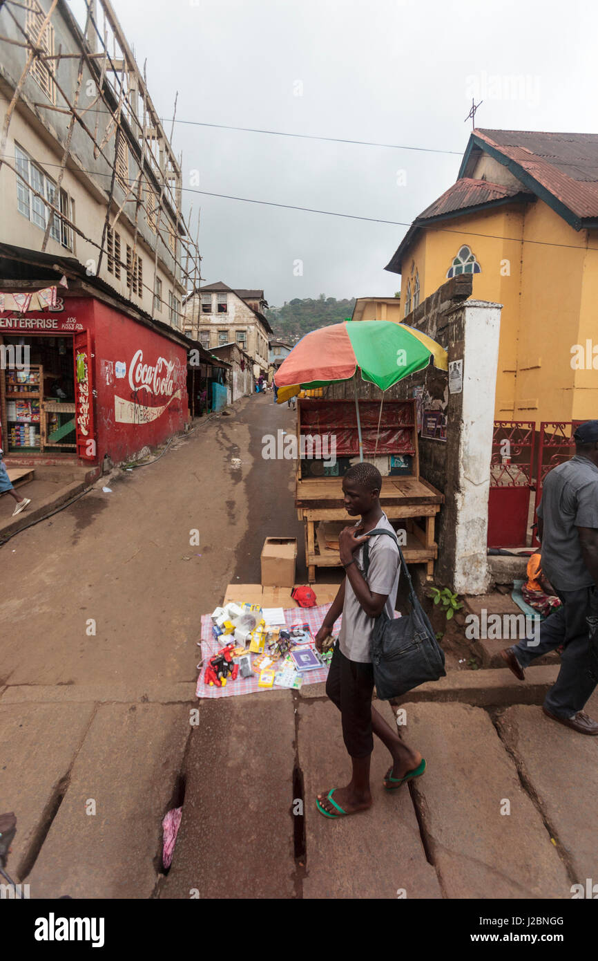 Africa, Sierra Leone, Freetown. A young man walking across an intersection. Stock Photo