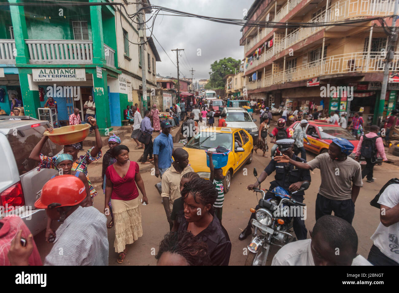 Africa, Sierra Leone, Freetown. Cars, motorcycles and pedestrians at a crowded intersection. Stock Photo