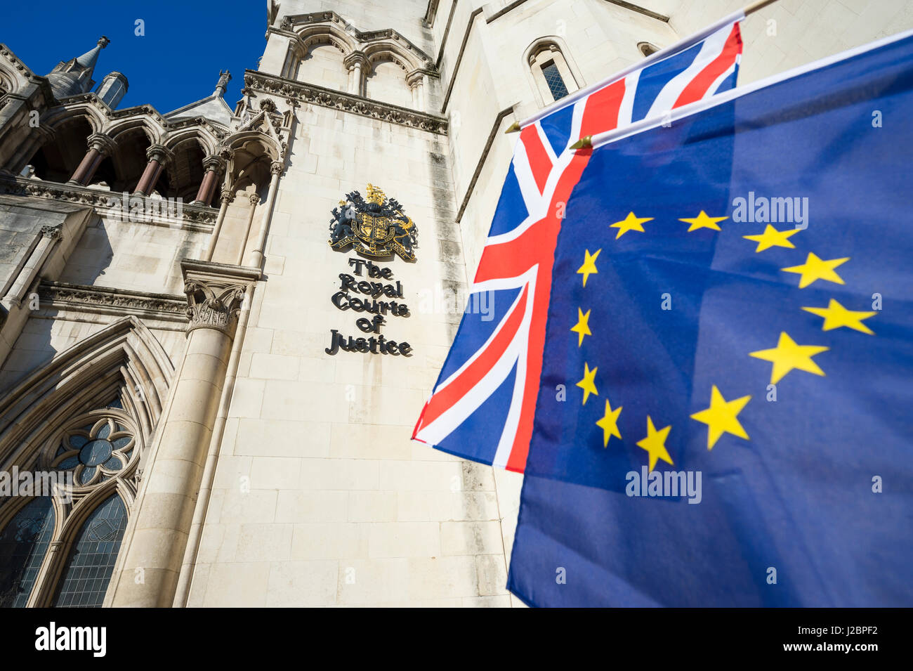 EU European Union and UK United Kingdom flags flying together in front of The Royal Courts of Justice in London, where some Brexit cases will be heard Stock Photo