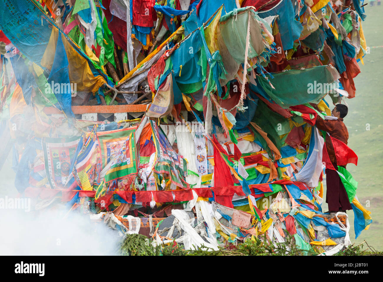 Wind Horse with man arranging Buddhist prayer flags at horse festival near Daofu, Tibetan area, Sichuan, China Stock Photo