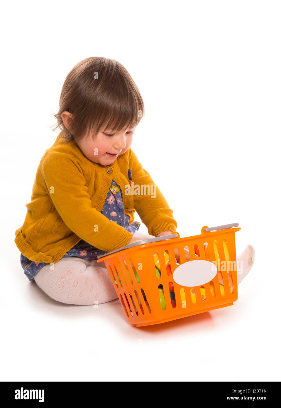 toddler playing with plastic food cutout Stock Photo