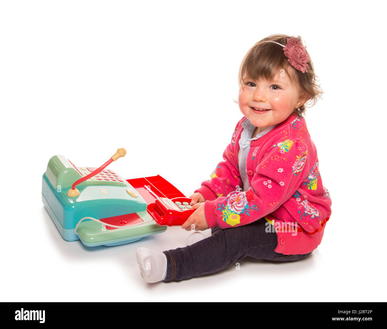 Toddler playing with a cash register in a studio Stock Photo