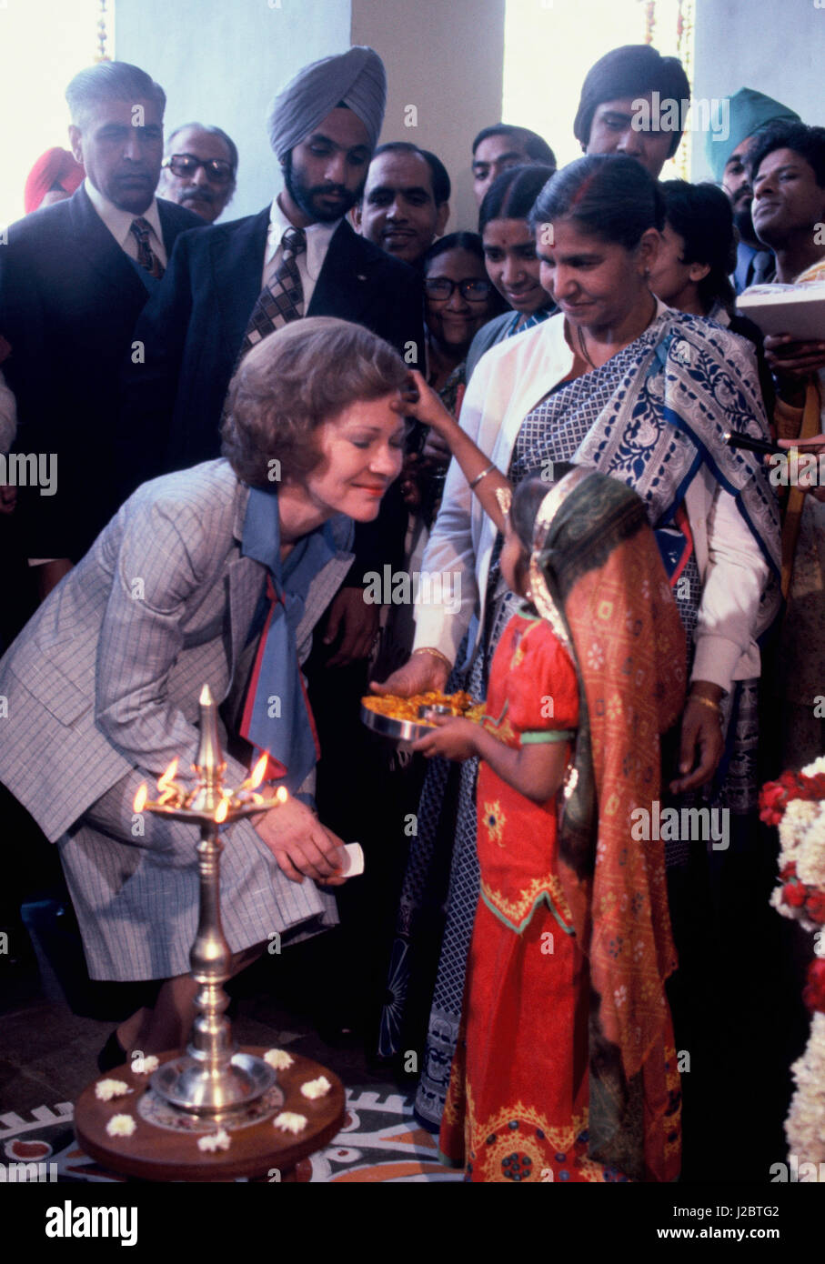 Rosalyn Carter India receives the traditional welcome of a child placing a red mark on her forehead. President Carter visits India on January 1, 1978 Stock Photo