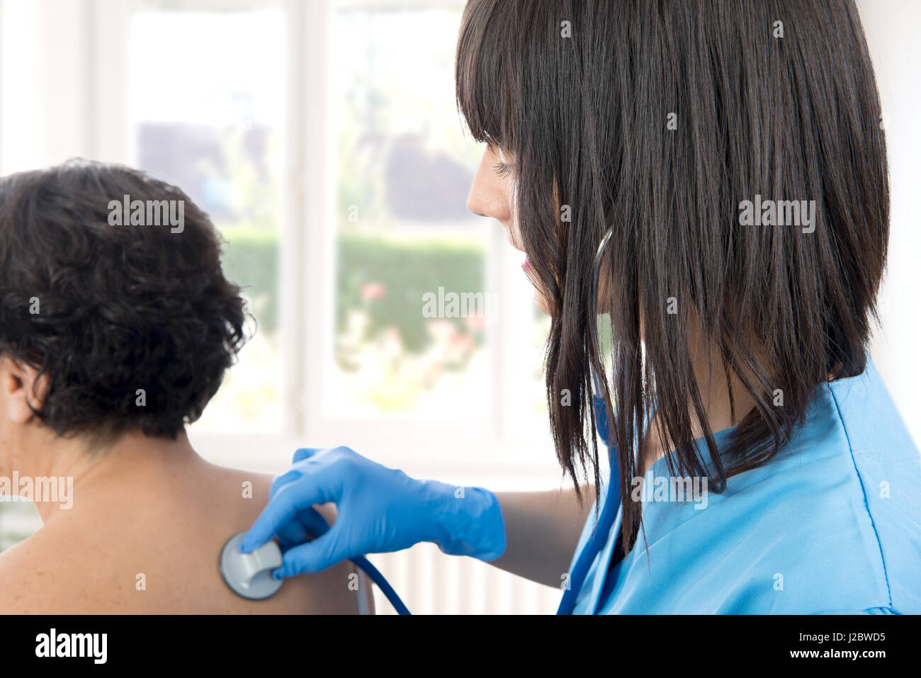 young female doctor examines a patient with a stethoscope Stock Photo ...