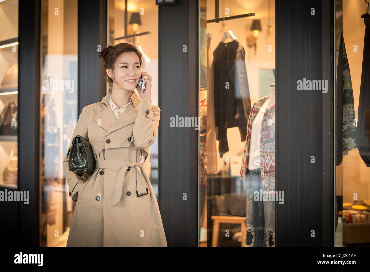 Young smiling woman in trench coat Stock Photo - Alamy