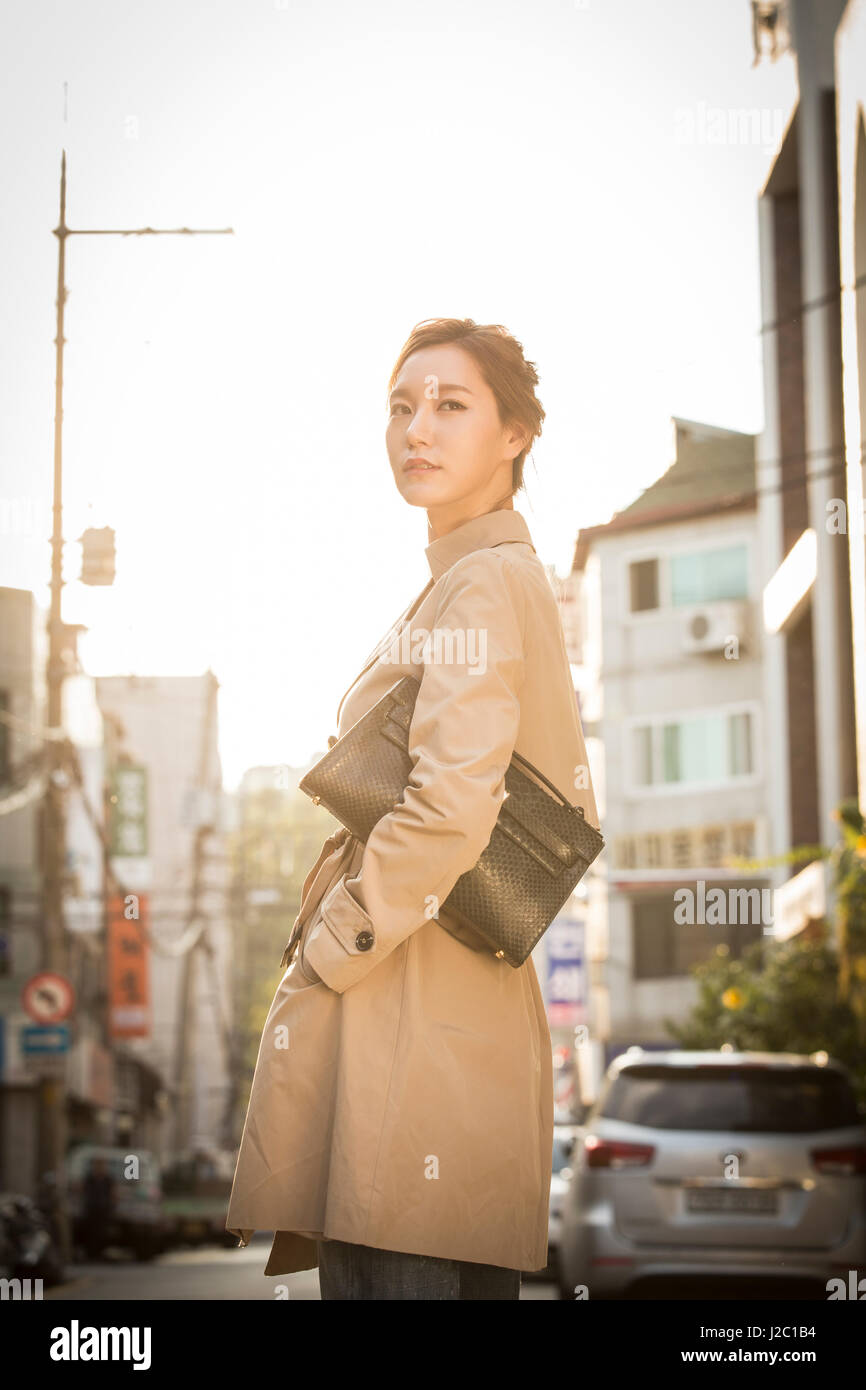 Young woman in trench coat Stock Photo - Alamy