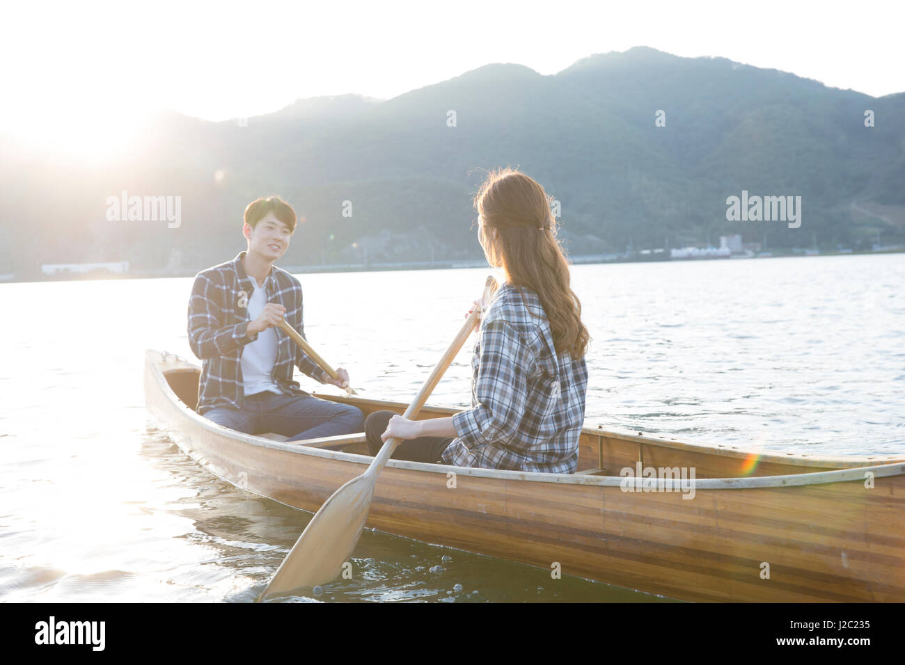Young couple travelers paddling a canoe Stock Photo