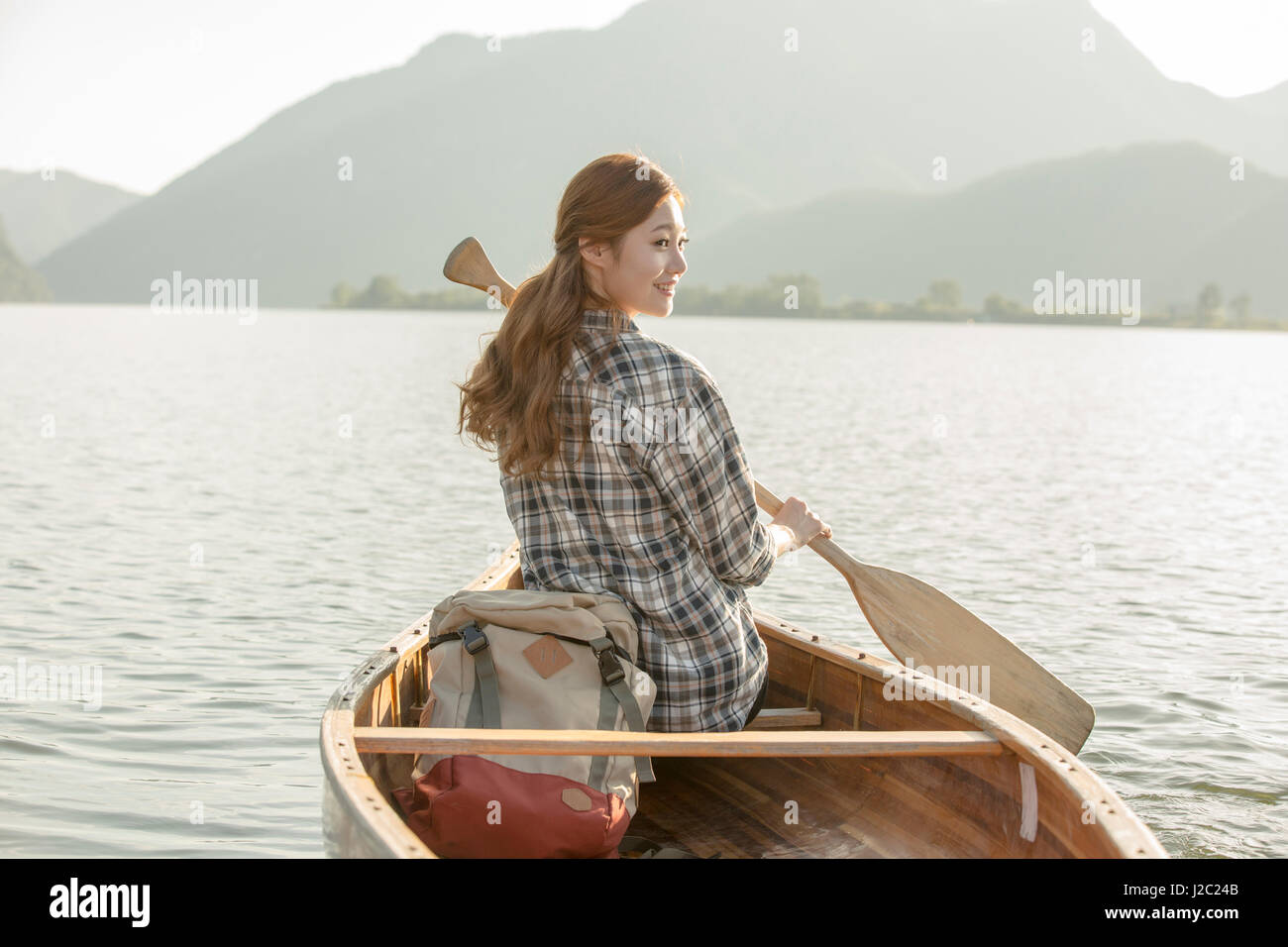 Back of young woman paddling a canoe Stock Photo Alamy