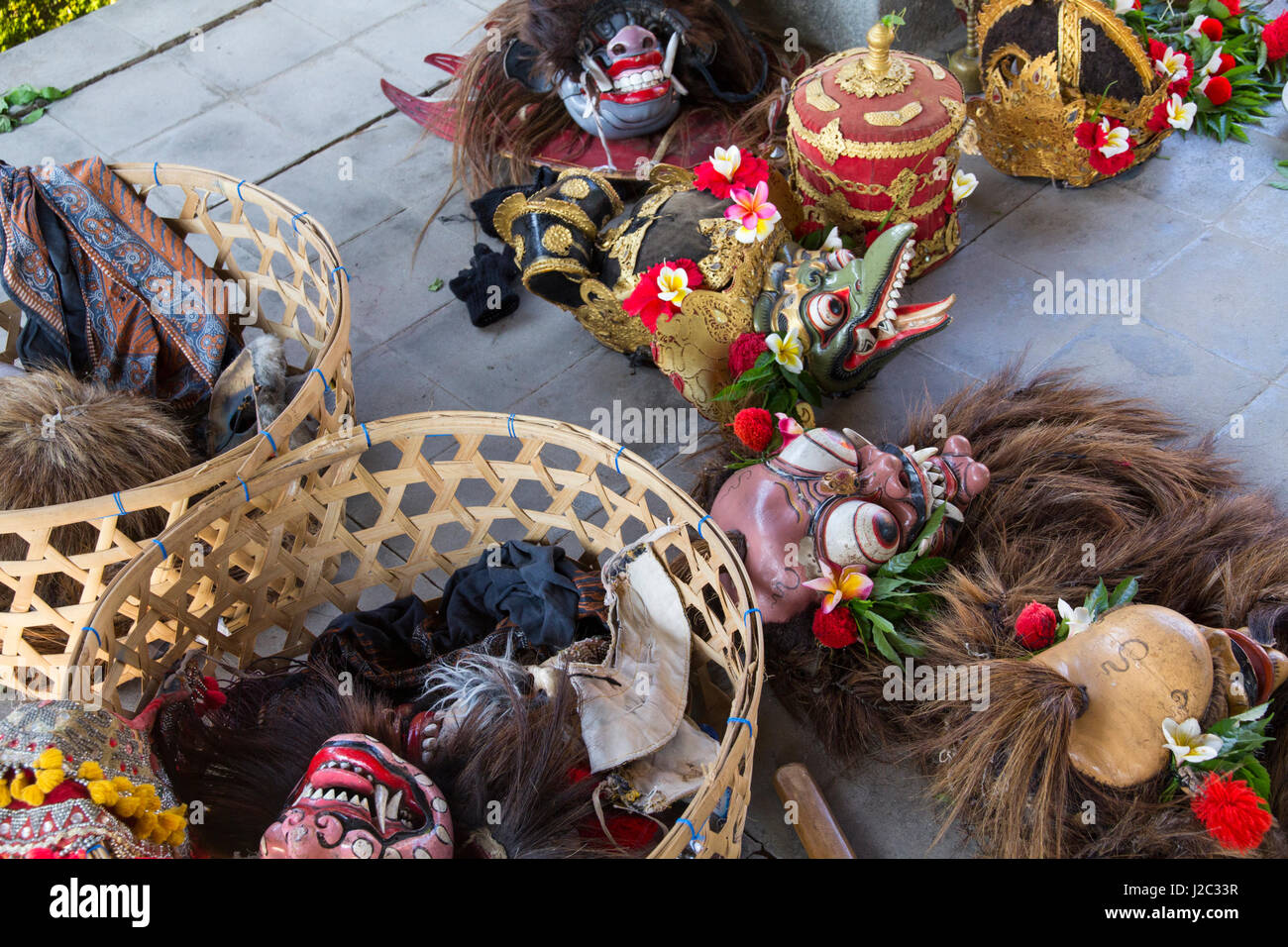 Indonesia, Bali. Balinese Barong masks and ceremonial head dresses decorated with red Hibiscus and Frangipani flowers in Bali, Indonesia. Stock Photo