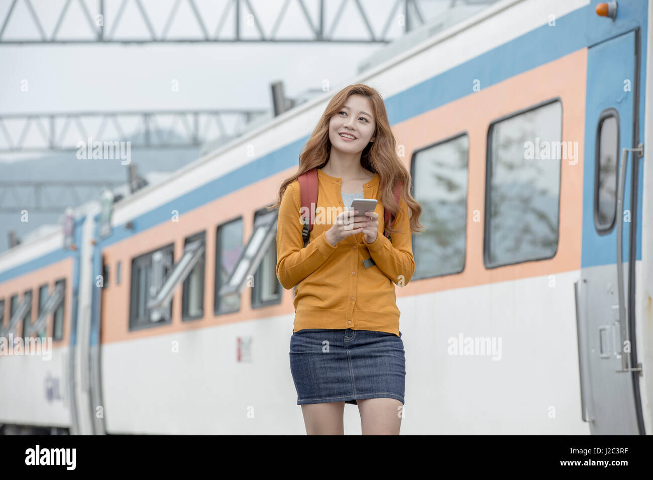 Young smiling female traveler at station Stock Photo