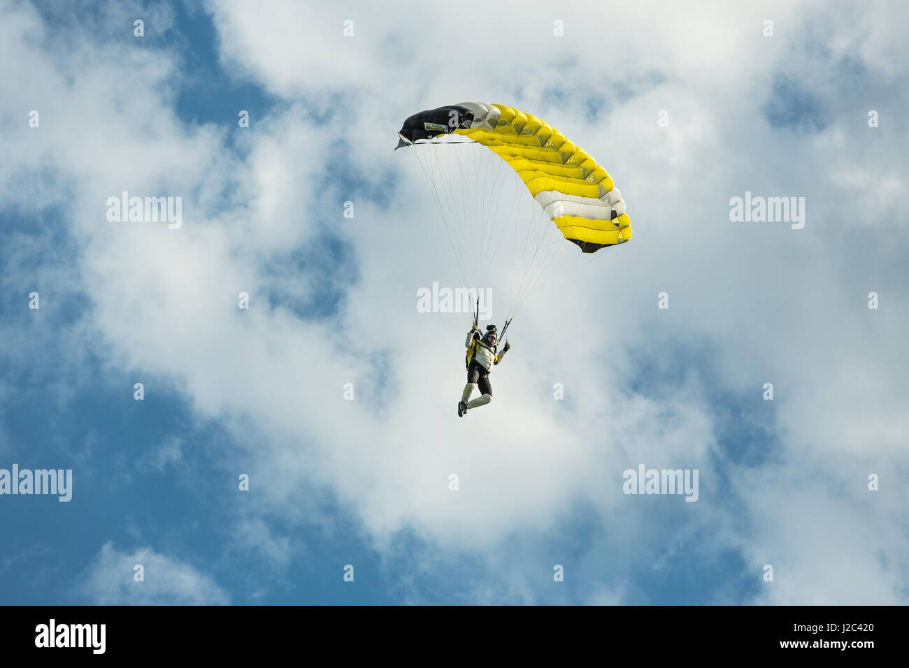 Pribram, CZE - August 19, 2016. Yellow paraglider flying against the cloudy sky in Pribram airport, Czech Republic Stock Photo