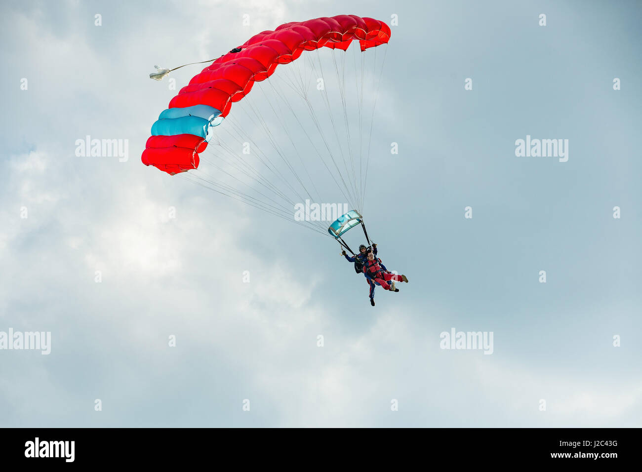Pribram, CZE - August 19, 2016. Tandem red paraglider flying against the cloudy sky in Pribram airport, Czech Republic Stock Photo