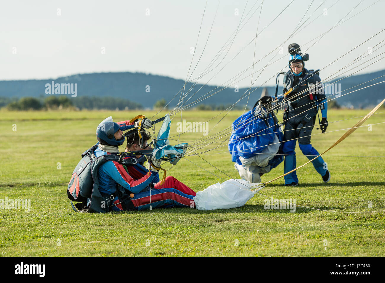 Pribram, CZE - August 19, 2016. Tandem red paraglider landing on grass in Pribram airport, Czech Republic Stock Photo