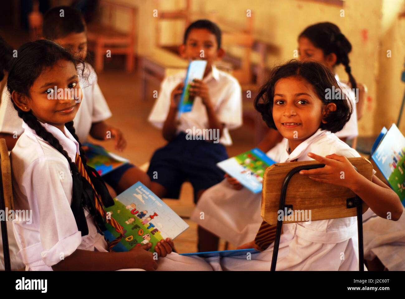 Sri Lanka, Colombo, children in uniform looking at UNICEF children book ...