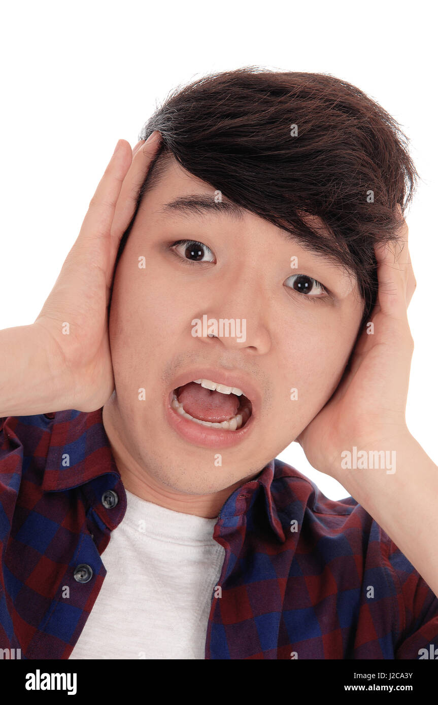 An young Korean man holding his hands on his face and screaming in ...