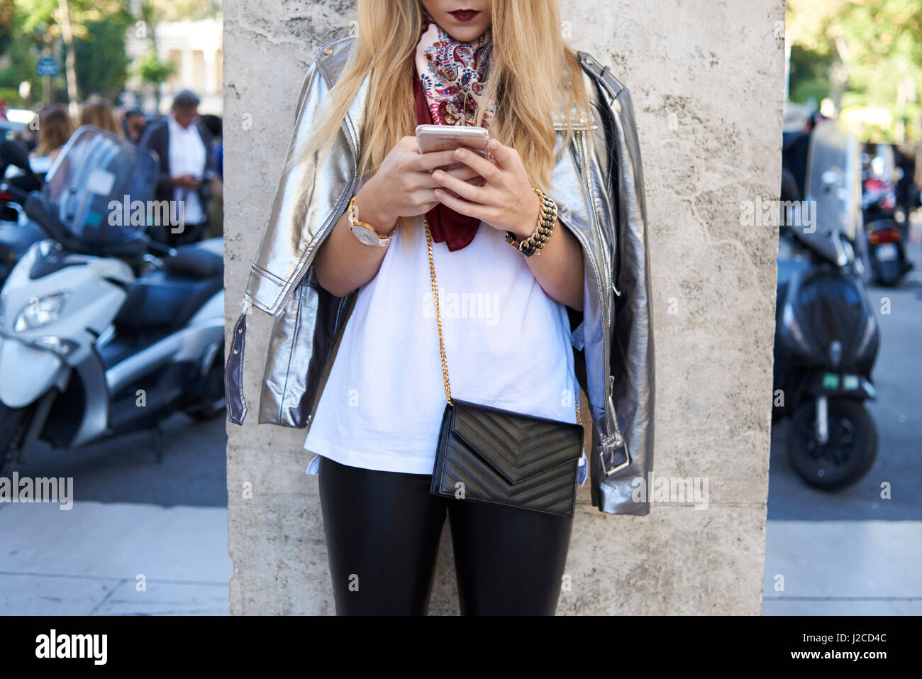 Woman using smartphone, silver jacket over shoulders, crop Stock Photo