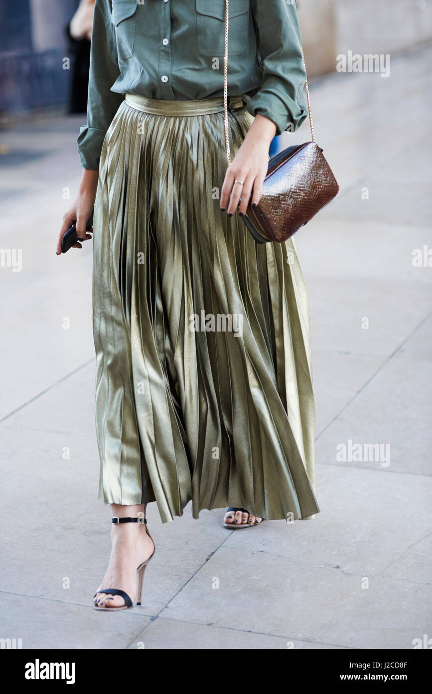 Woman in long, gold pleated skirt walking, vertical crop Stock Photo - Alamy