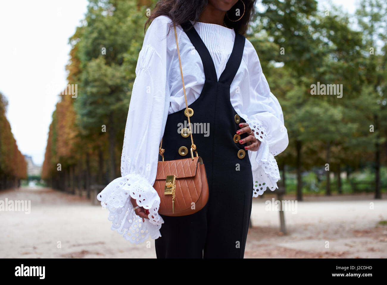 Woman in dungarees and a gypsy blouse with bag, mid section Stock Photo