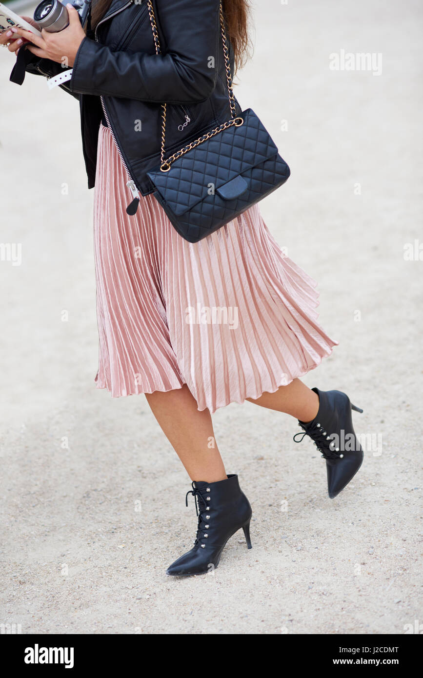 Woman in pleated skirt with designer handbag, vertical crop Stock Photo
