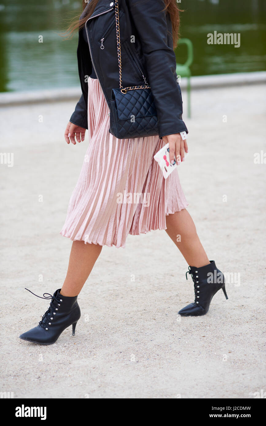 Woman in pleated skirt with designer handbag walking, crop Stock Photo