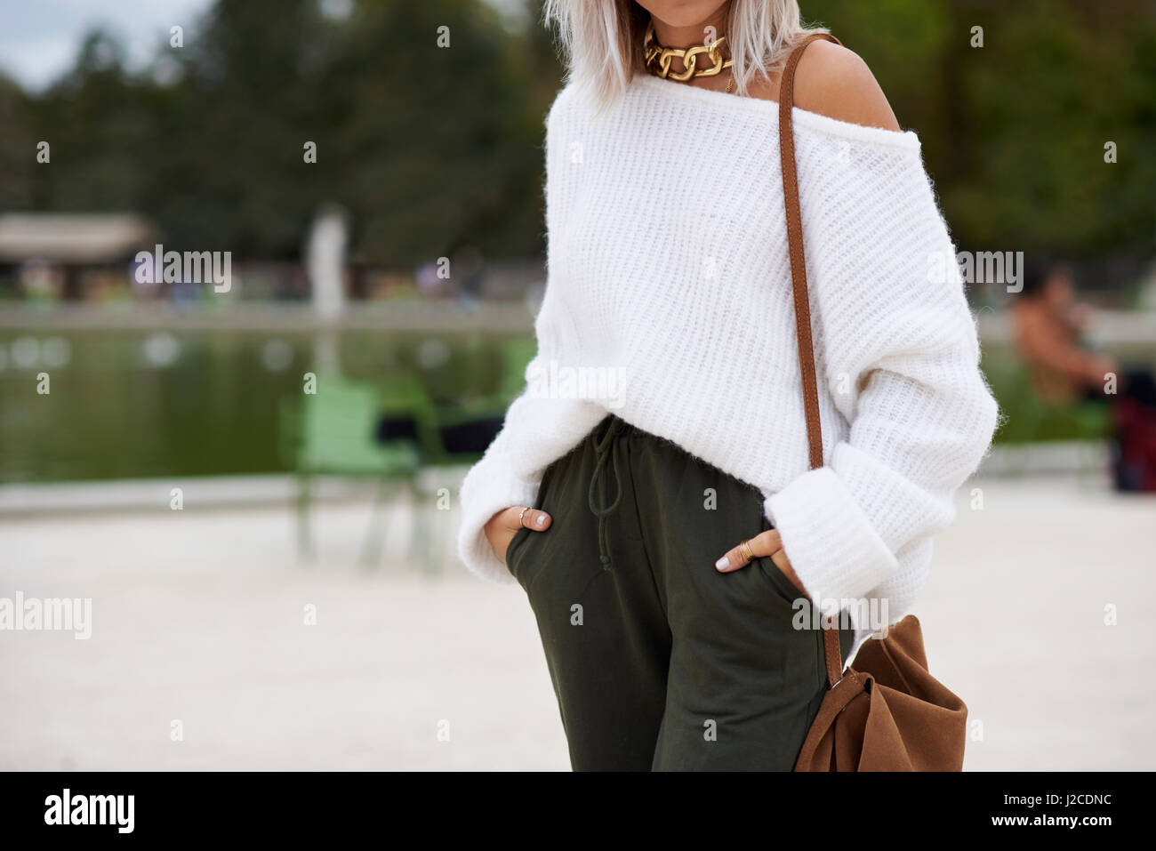 Woman in park wearing white sweater and sweatpants, crop Stock Photo