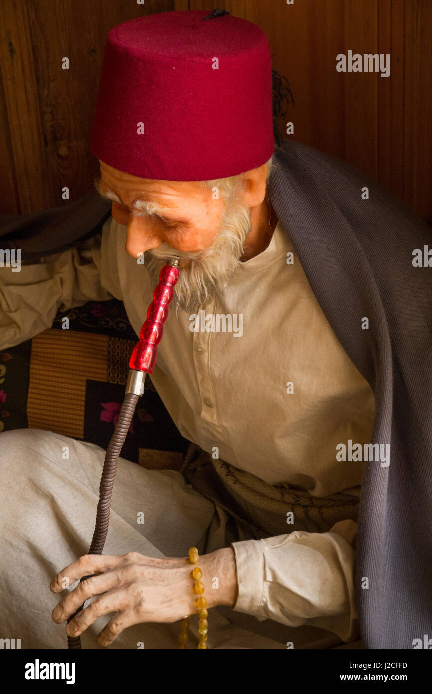 Turkey, Gaziantep. Wax model of Turkish man in traditional clothes smoking a hookah, also known as a waterpipe, narghile, arghila, qalyan, shisha. Editorial Use Only. Stock Photo