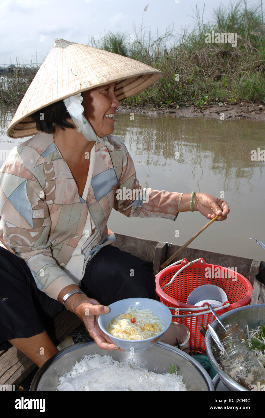 Asia, Vietnam. Women preparing pho from a boat at the market, Chau Doc (Editorial Usage Only) Stock Photo
