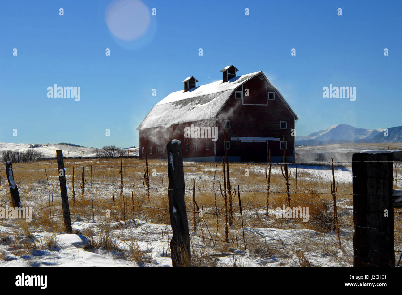 Snow Blows From The Roof Of A Rustic Wooden Barn In Colorado