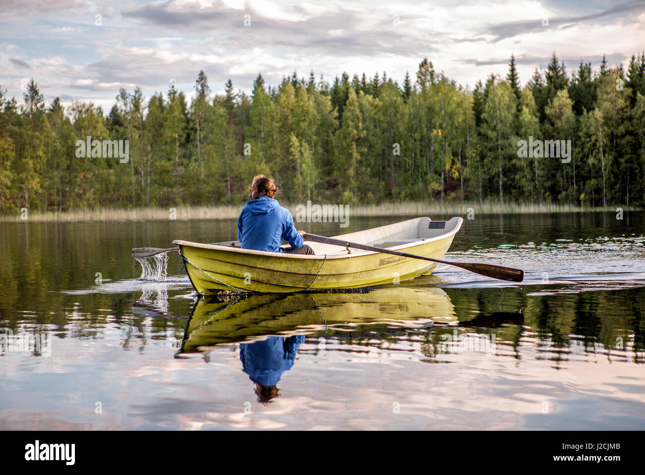 Finland, 10 days live in the Mökki, on an island, only can be reached by rowing boat. Linnansaari National Park, man rowing over the lake Stock Photo