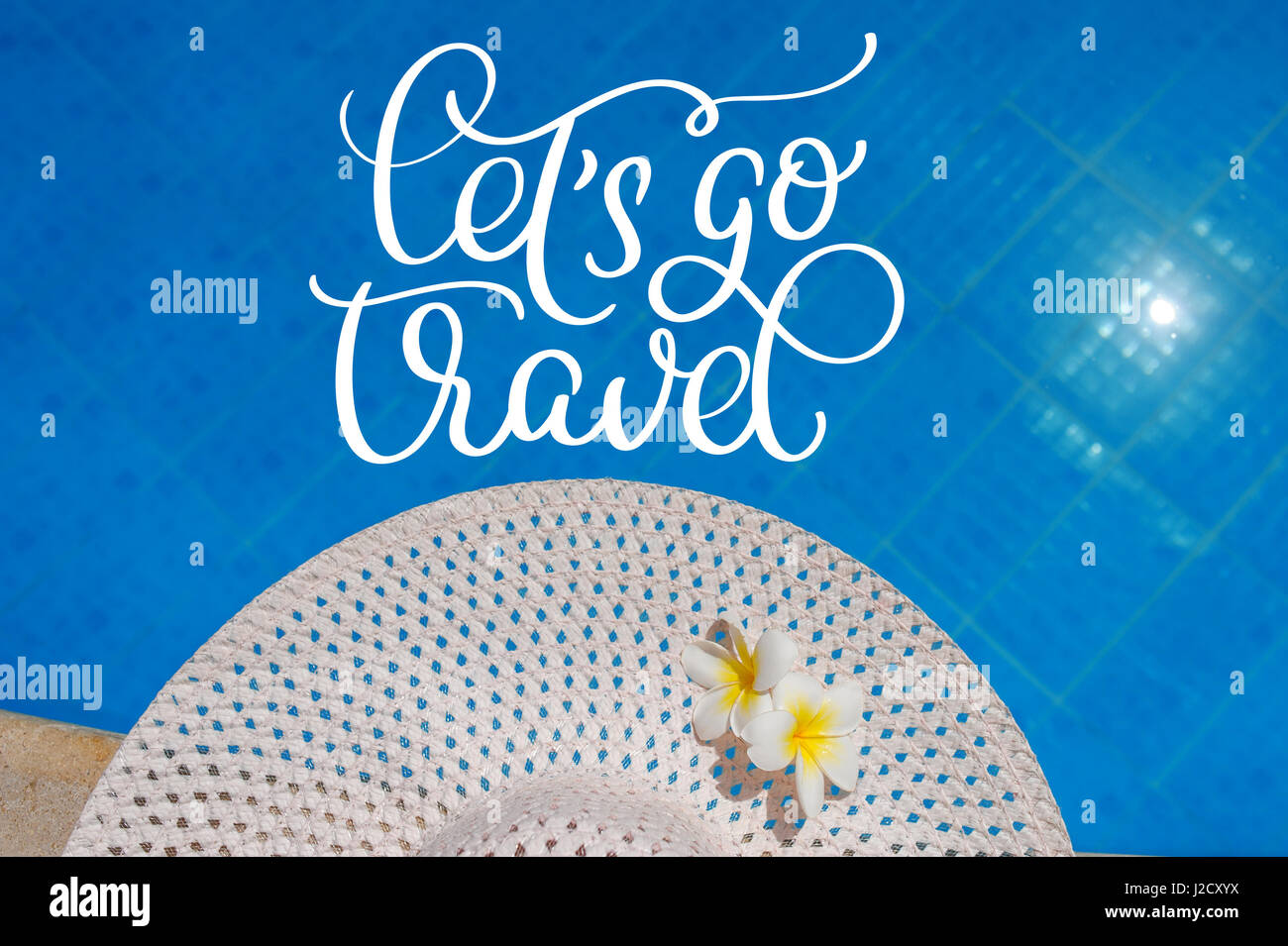 Big white hat on the edge of the pool and text Lets go travel. Calligraphy lettering hand draw Stock Photo