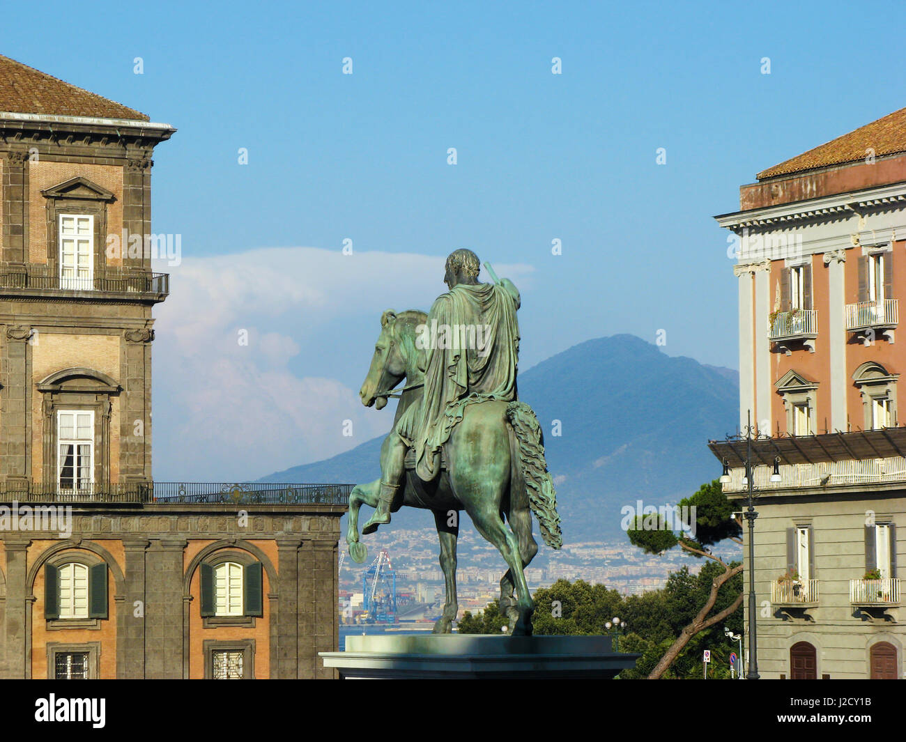 Piazza del Plebiscito, Naples - Statua di Carlo III di Spagna (Carlo Sebastiano di Borbone) with part of the Vesuvius volcano in the background Stock Photo