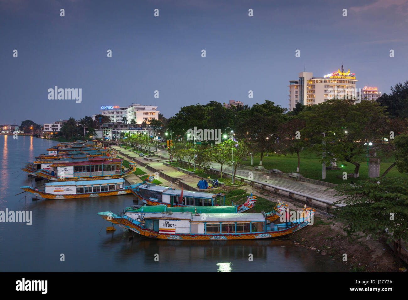 Vietnam, Hue. Elevated view of Century Hotel, Perfume river and dragon boats, dusk Stock Photo