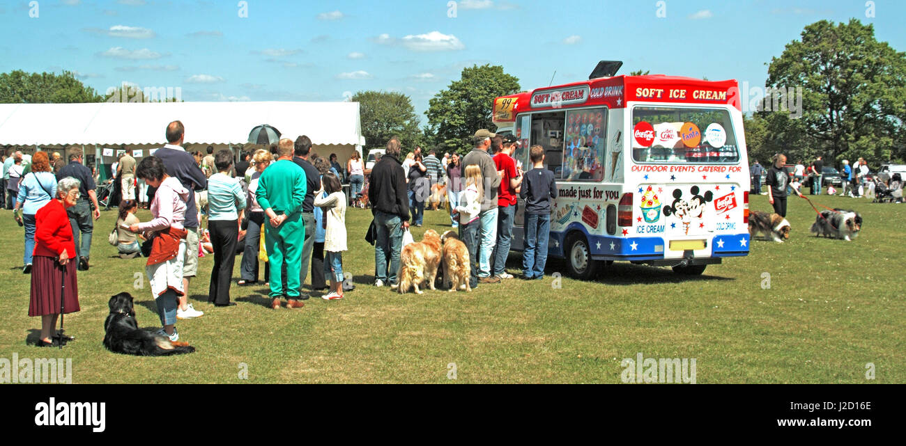 Dog show on a summer day people standing & queuing at ice cream van some with their dogs all waiting to purchase icecream or drinks Essex UK Stock Photo