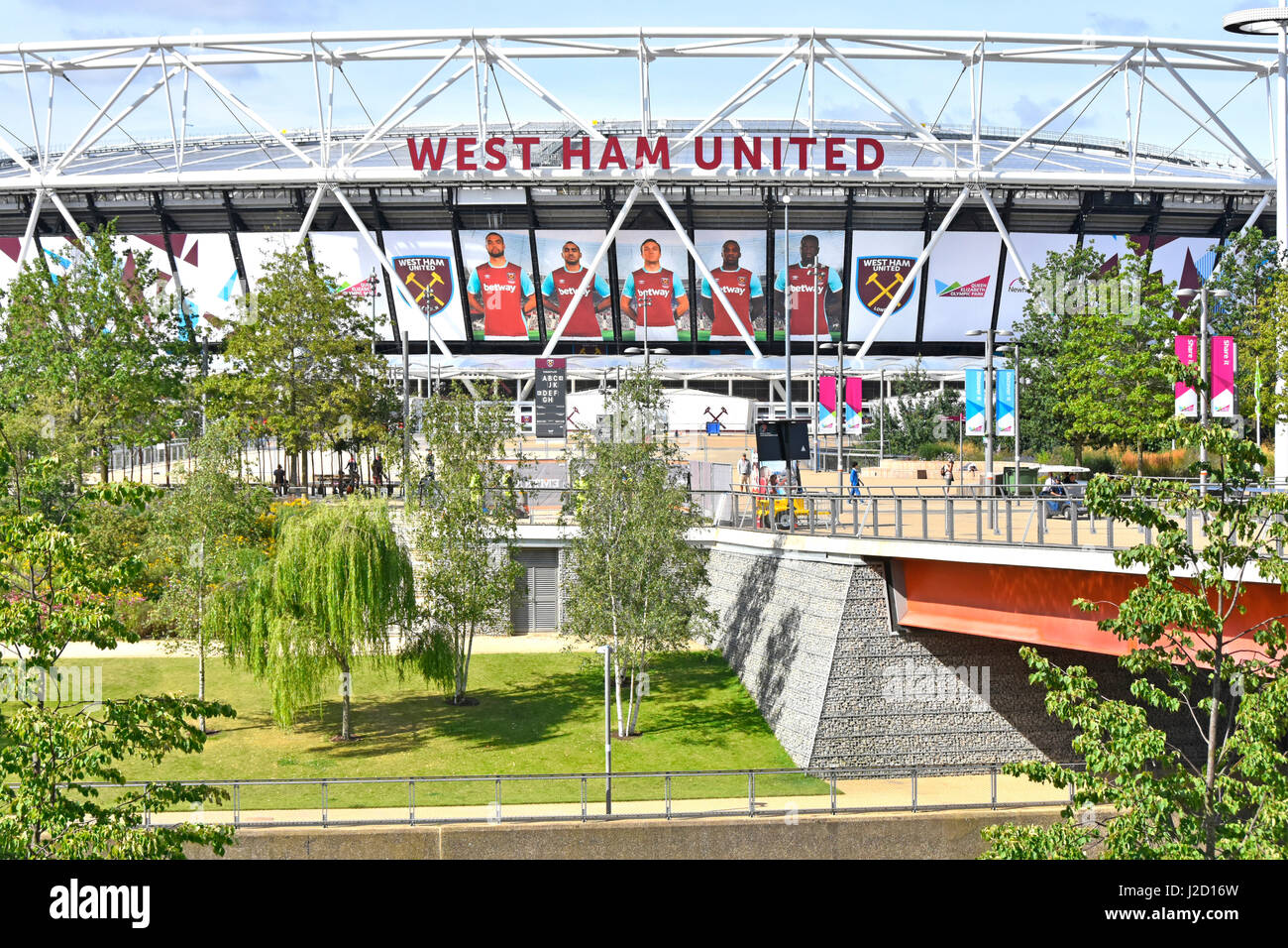 Queen Elizabeth Olympic Park Stratford Newham London England UK lawn & tree riverside landscaping in front of converted 2012 Olympic West Ham stadium Stock Photo