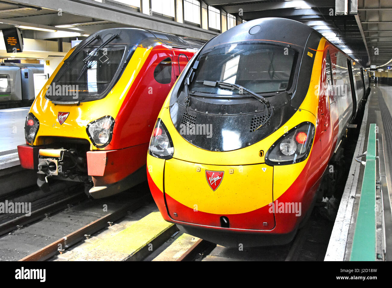 Two streamlined Virgin train units operated by Virgin Trains at Euston railway station platforms London England UK provide inter city public transport Stock Photo