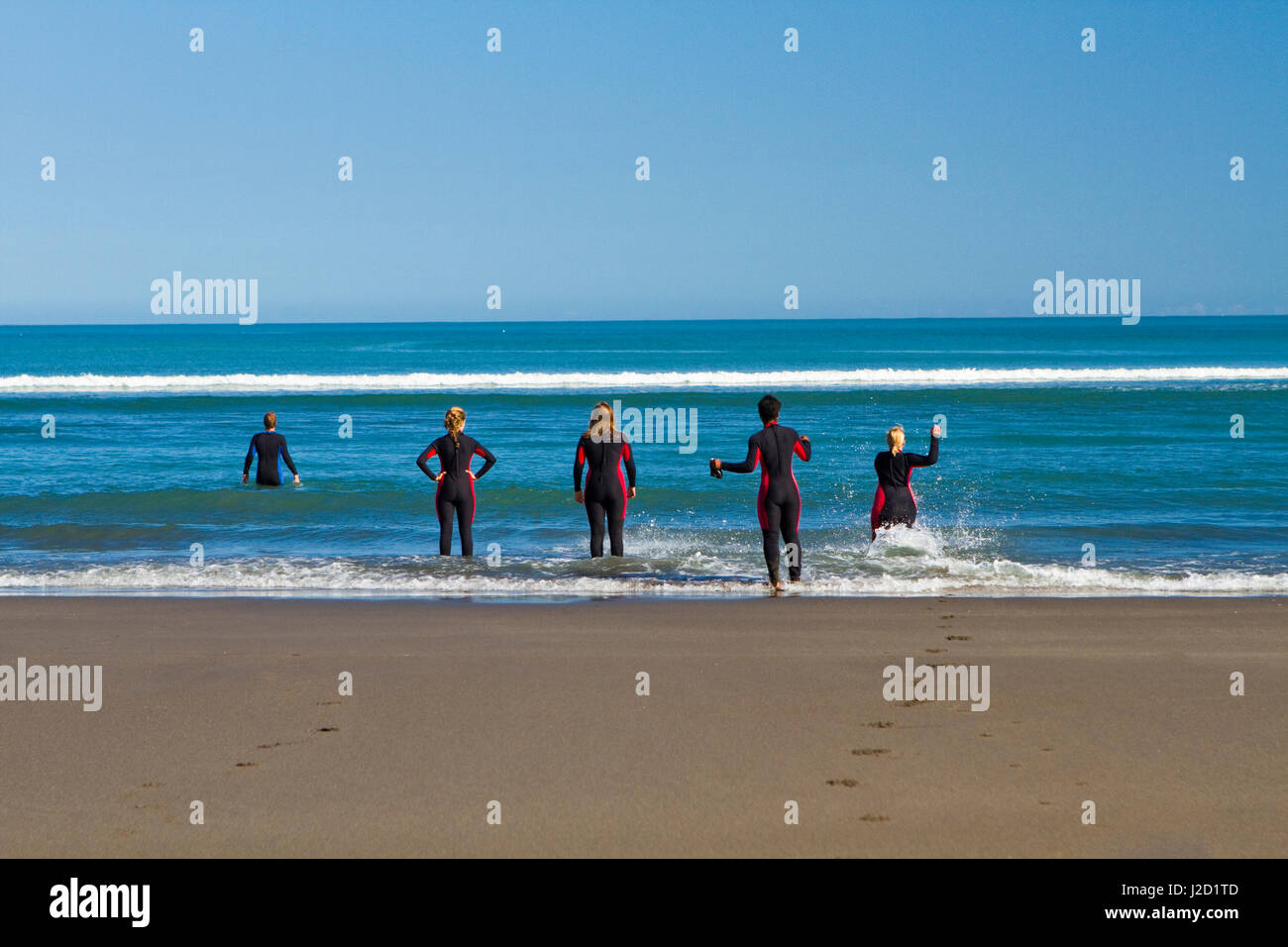 Surf school instructors give their surf students pointers on how to improve in Raglan, New Zealand. Stock Photo