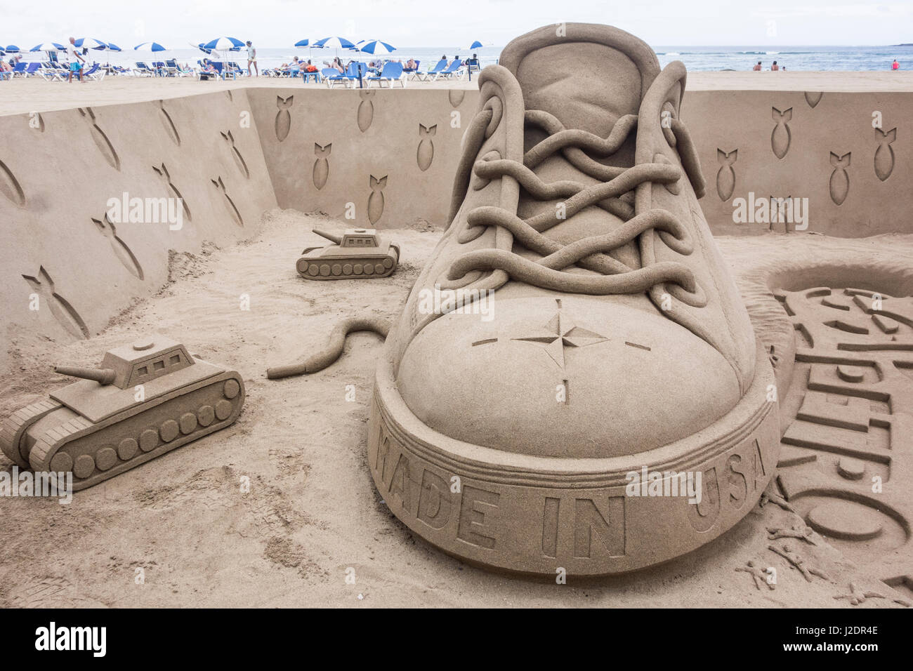 Las Palmas, Gran Canaria, Canary Islands, Spain. 28th April, 2017. Sand sculptor Etua Ojeda`s works nearly always have a social/political message. This anti 'imperialistic' sculpture on the city beach is called 'Criminal Footprint'. Quote from sculptor: 'The sculpture deals with the political reality in a symbolic way through the footprint left by the imperialist power and its allies, all of them governed by the economic powers in the shadows, pulling the strings of western political parties and their puppet politicians'. Credit: ALAN DAWSON/Alamy Live News Stock Photo