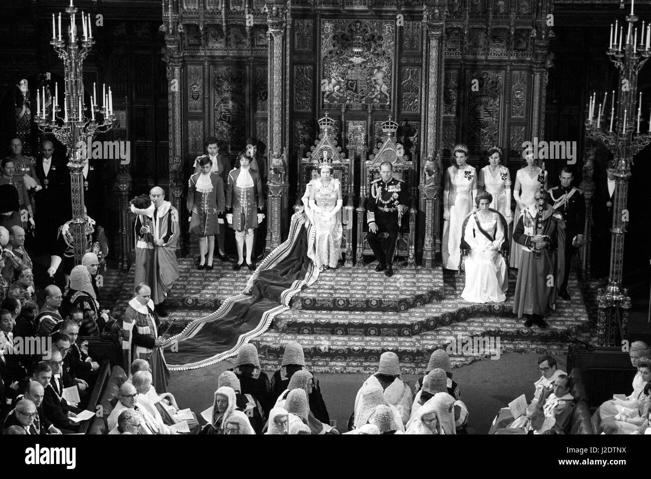 Queen Elizabeth II and Prince Philip, Duke of Edinburgh, seated on their thrones in the Chamber of the House of Lords shortly before the Queen delivered her speech for the State Opening of Parliament. Also in the image are Princess Anne (r) and her husband Captain Mark Phillips (on dais steps, r) and (foreground, left) The Cap of Maintenance, The Lord Shepherd, and (right) The Sword of the State, Marshal of the Royal Air Force the Lord Elworthy. Stock Photo