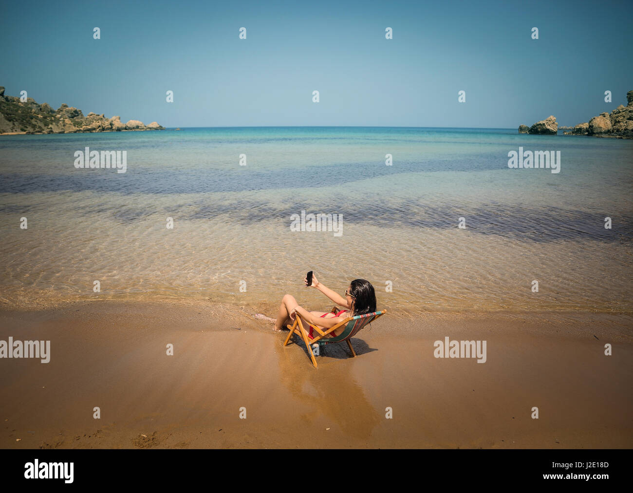 Woman sitting on chair in the sea Stock Photo