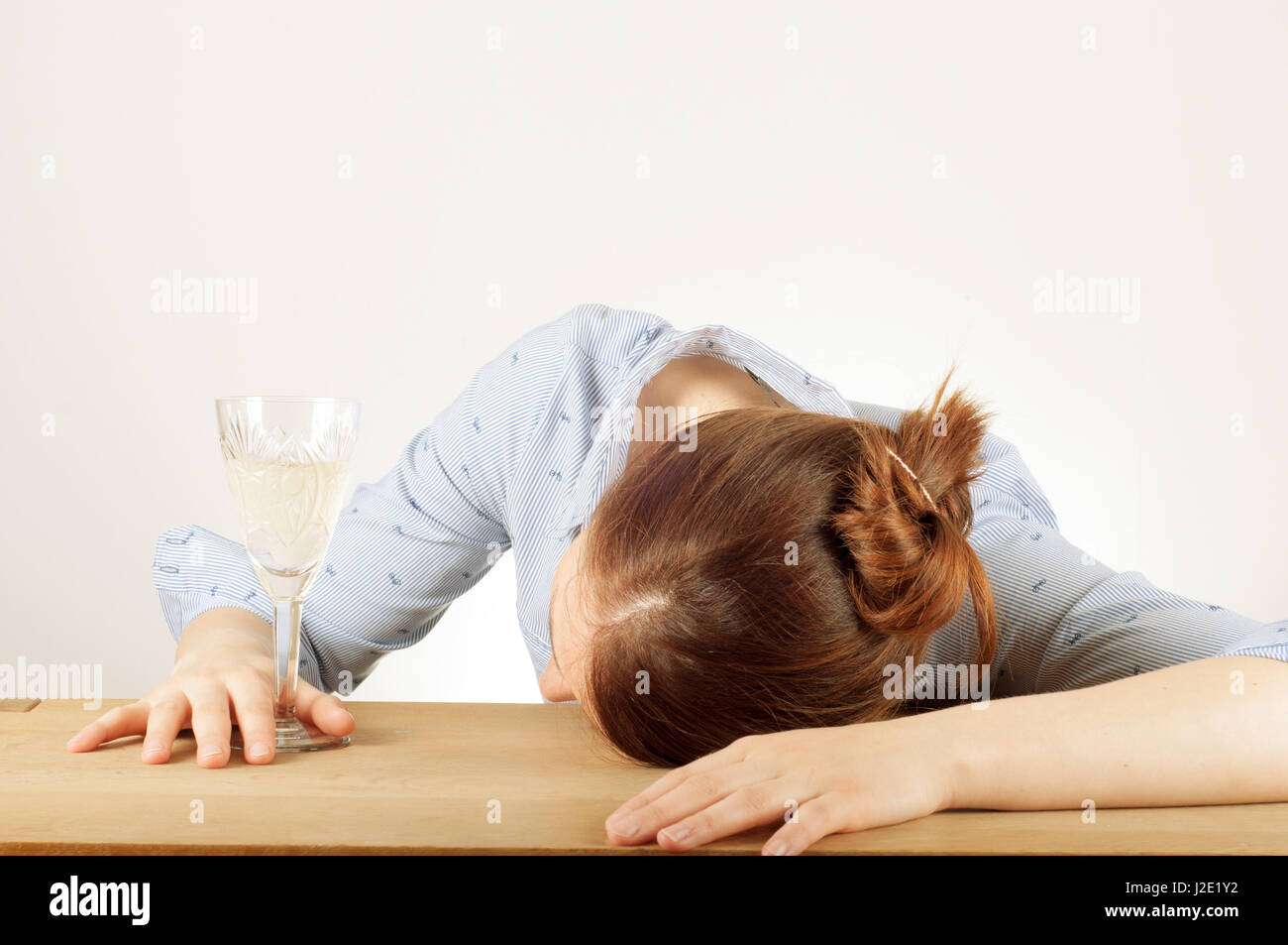 Young woman drinking champagne with a feeling of despair. Addicted to alcohol, alcoholism concept, social problem Stock Photo