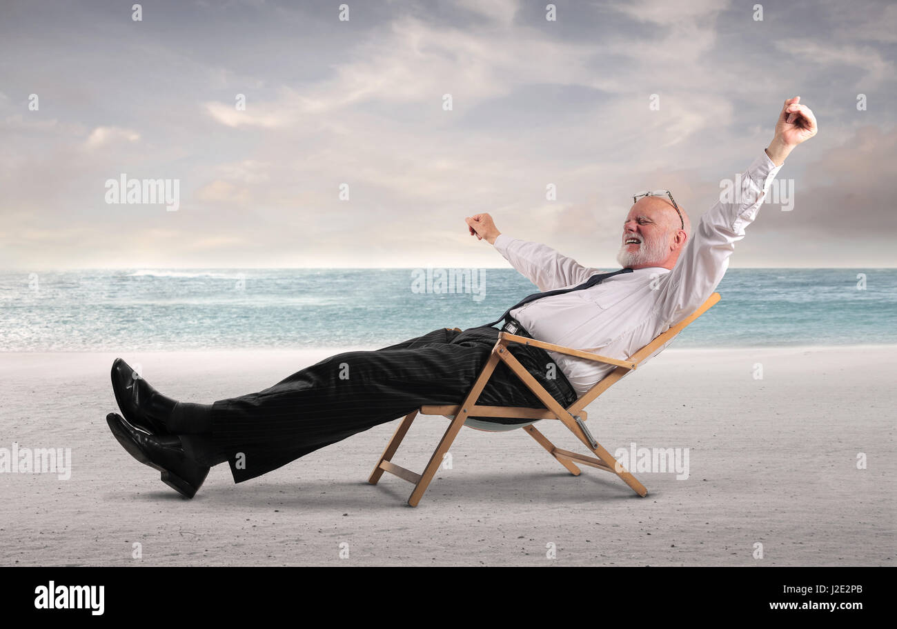 Old businessman relaxing on beach Stock Photo