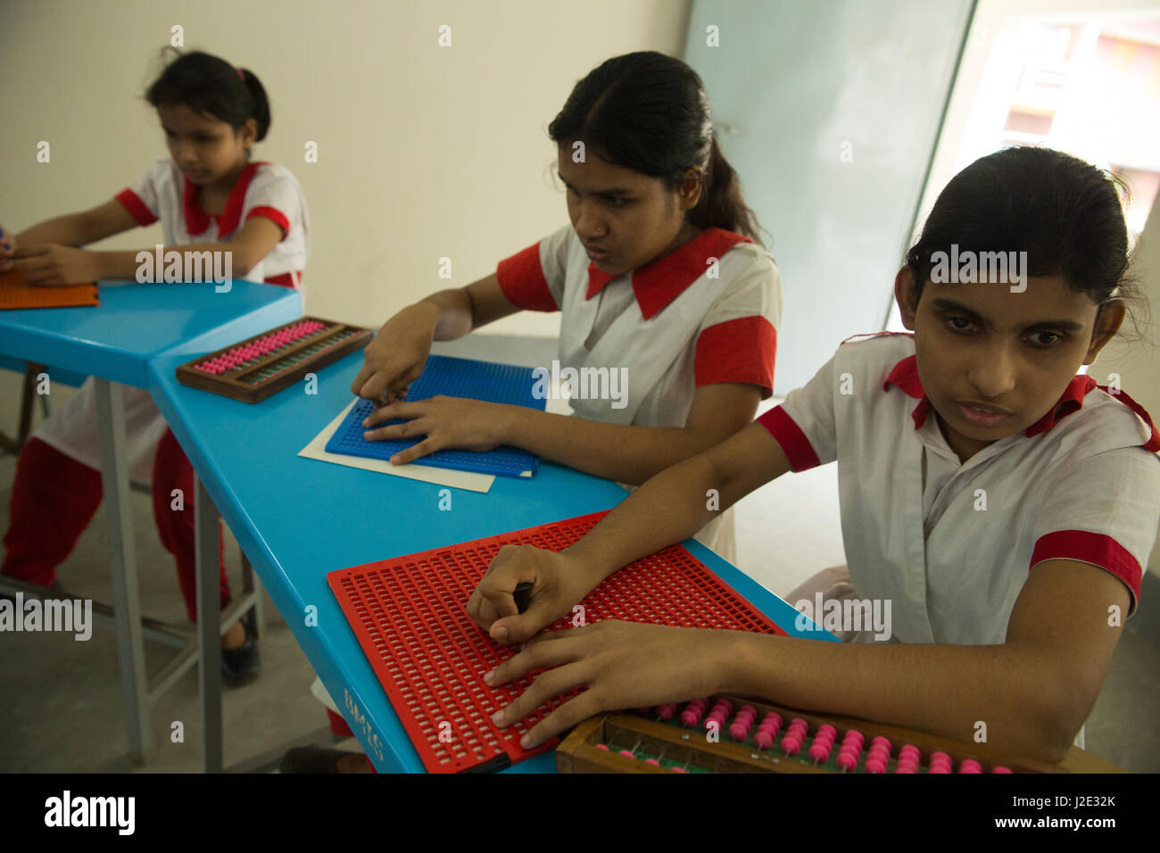 Visually impaired girl students learn in classroom with the help of