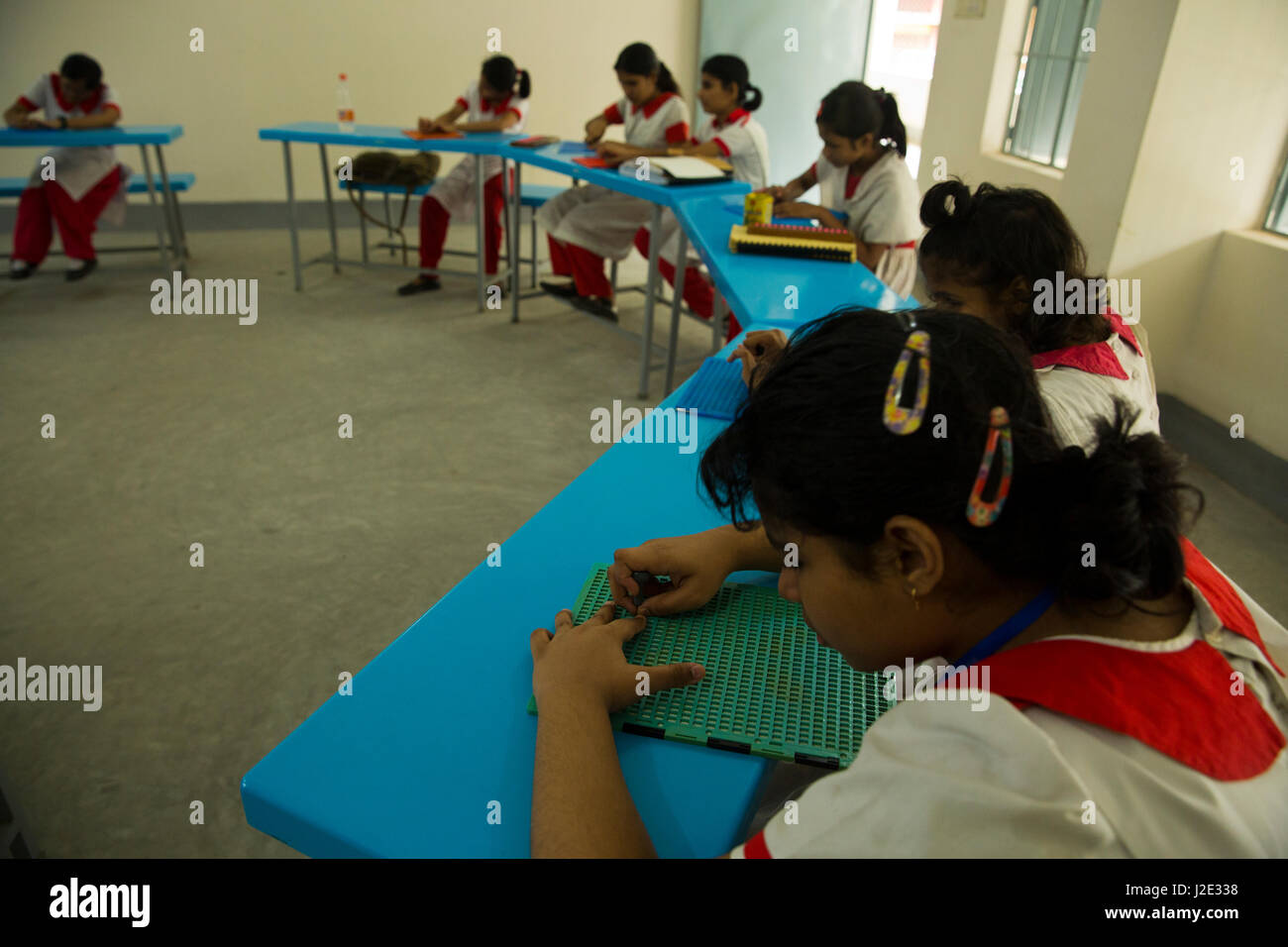 Visually impaired girl students learn in classroom with the help of